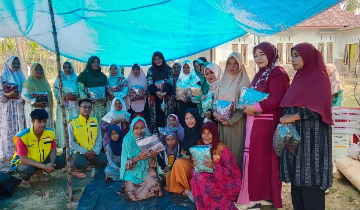 Relawan dalam kegiatan Bansos Sahabat Yatim menyerahkan mukena di Aceh Tamiang.